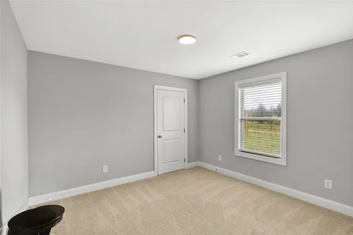 Soft carpeting pairs with a classic window looking out to the neat yard.