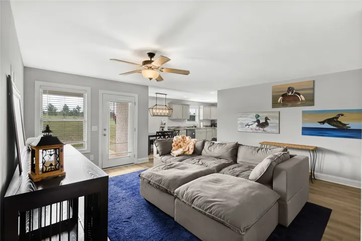 An open layout connects the living room to the kitchen under high ceilings.