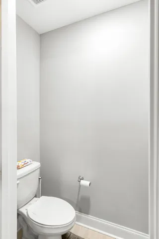 Crisp trim and light flooring define this minimalist powder room space.
