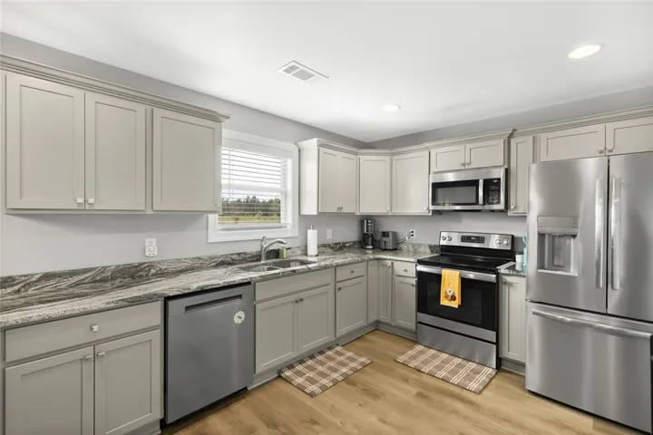 Ample cabinetry and stone countertops frame this modern culinary space.