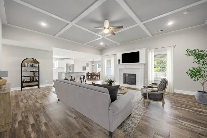 Gleaming hardwood floors and a classic coffered ceiling define this welcoming open-concept living space.