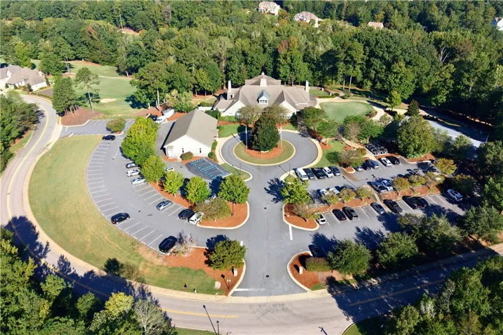 An aerial perspective reveals the expansive grounds and clubhouse of this wooded golf course community.
