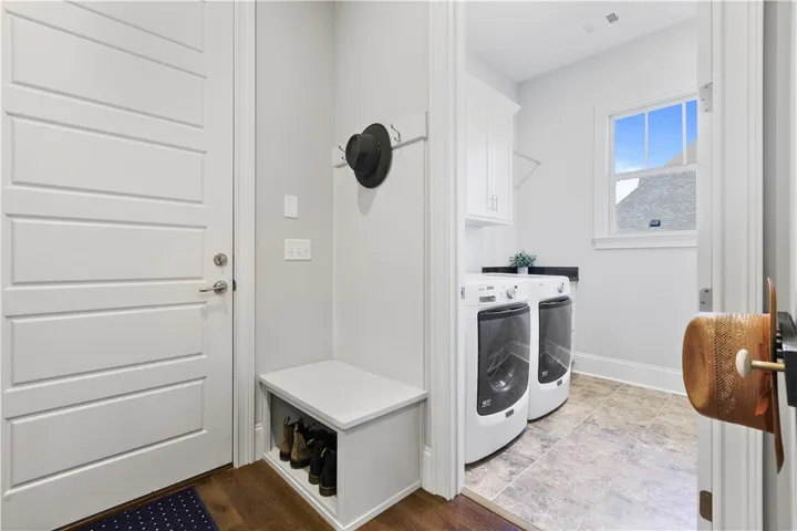 Functional mudroom built-ins transition seamlessly into a dedicated laundry room with tile flooring.