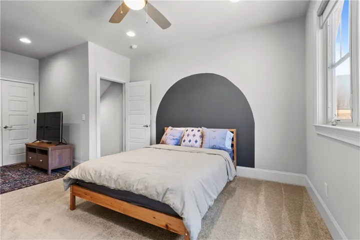 Plush carpeting and natural light define this cozy bedroom retreat.