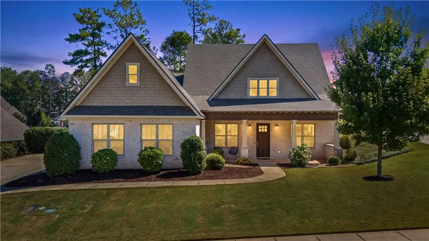 Striking architectural gables and warm brickwork define this inviting multi-level residence at dusk.