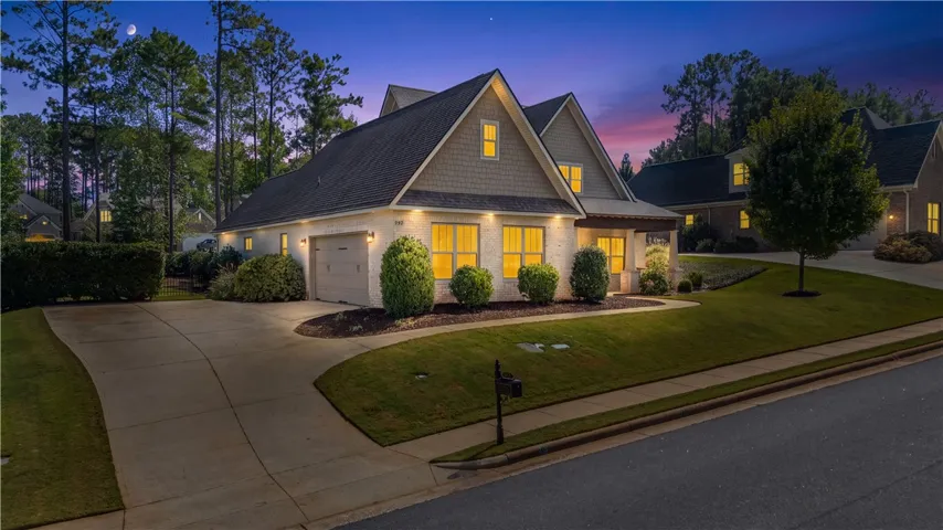 An inviting exterior features a large lot with manicured landscaping, and classic architectural details.