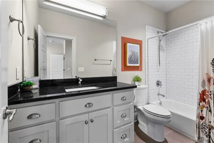 Granite counters and tiled tub surrounds highlight this updated space.