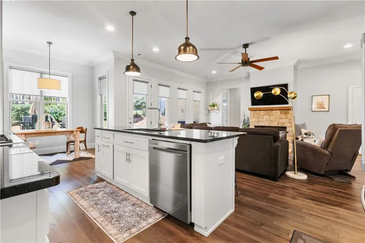 Rich hardwood floors anchor this open concept layout connecting the kitchen and living space.