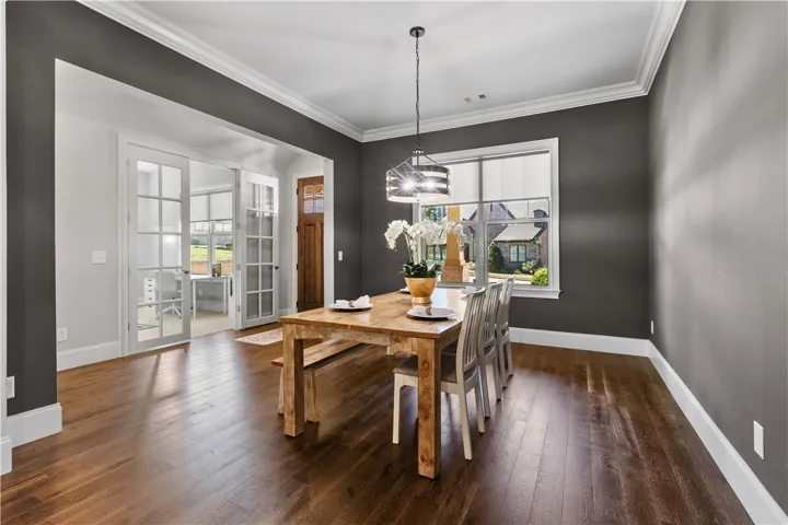 Rich hardwood floors contrast beautifully with deep wall tones in this elegant dining​​‌​​​​‌​​‌‌​‌‌​​​‌‌​‌​‌​‌​​​‌​​ room.