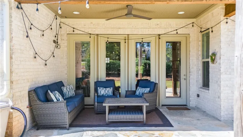 Whitewashed brick walls and flagstone flooring create an inviting shaded outdoor living space.
