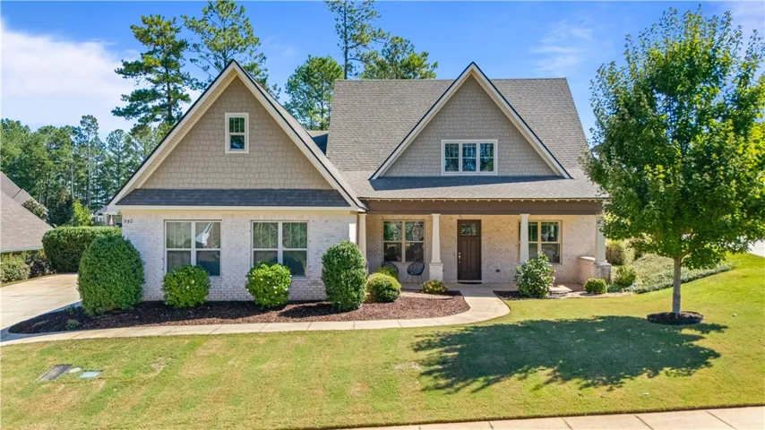 An inviting front porch welcomes guests to this beautiful brick home.