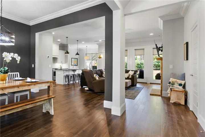 Rich hardwood flooring stretches through the open-concept design accented by elegant crown molding.