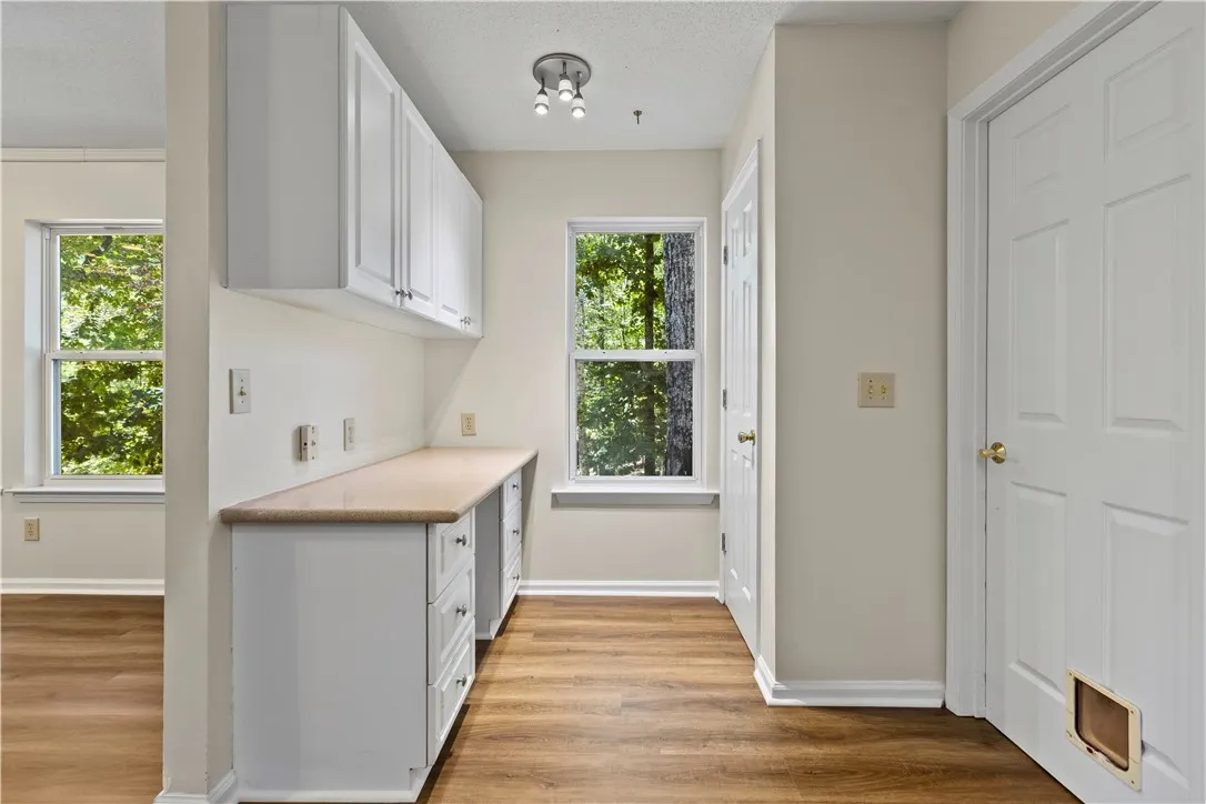 Functional built-in desk, pantry, and new LVP flooring maximize utility in this versatile workspace.