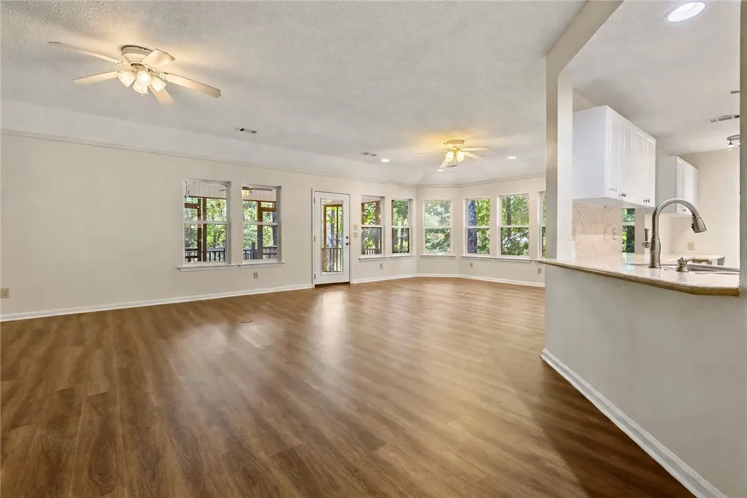 An open floorplan connects the spacious living and dining area to the kitchen through a breakfast bar. New LVP flooring
