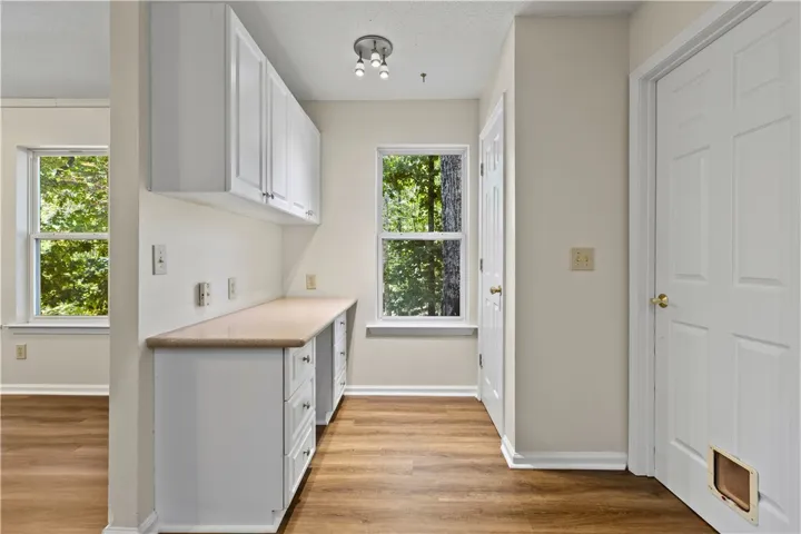 Functional built-in desk, pantry, and new LVP flooring maximize utility in this versatile workspace.