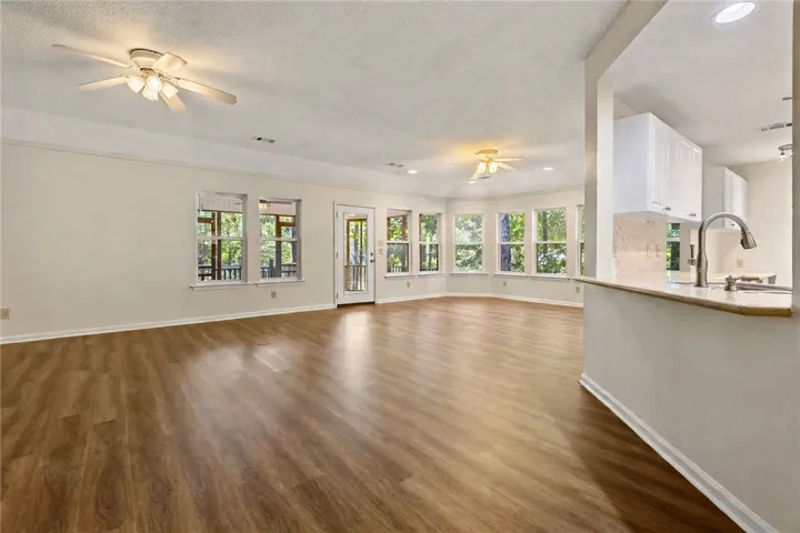 An open floorplan connects the spacious living and dining area to the kitchen through a breakfast bar. New LVP flooring