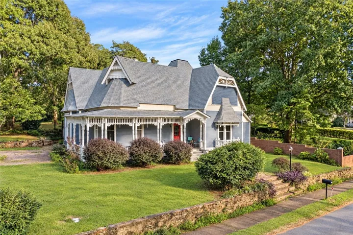 A wrap-around porch and classic gables highlight this classic two-story Victorian home.