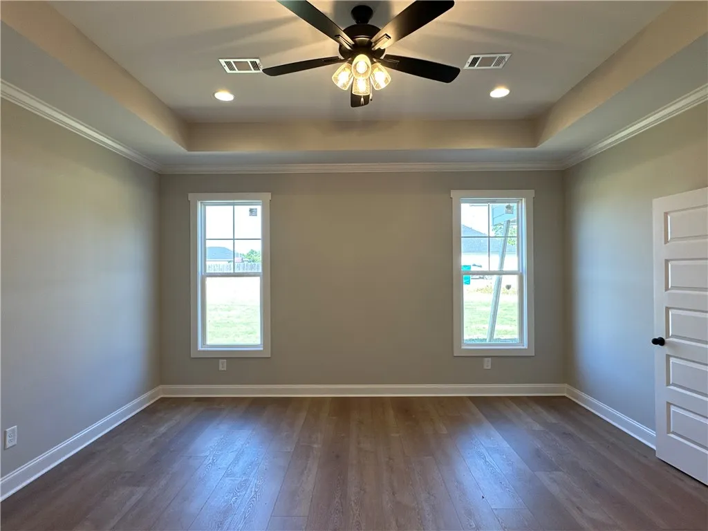 Elegant wood-look flooring and a recessed tray ceiling define this versatile space.