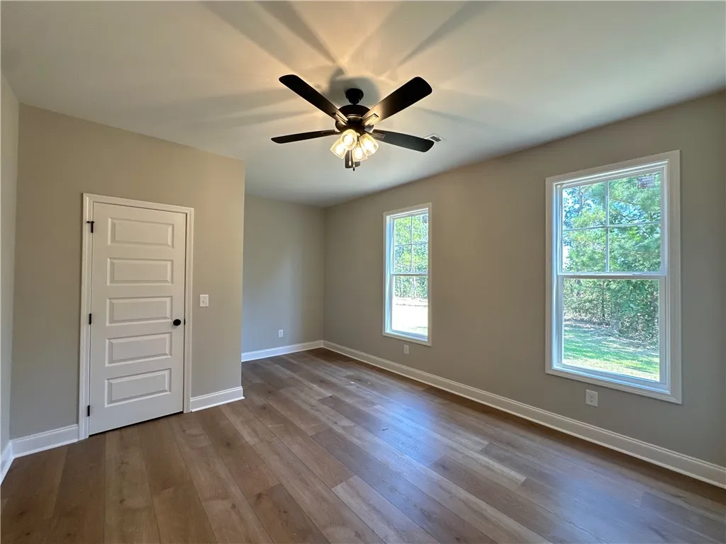 Gleaming hardwood floors and classic crown molding define this serene bedroom space.