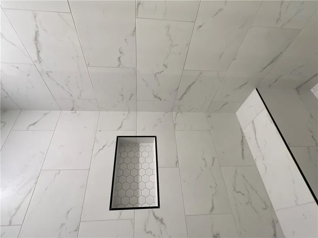 Elegantly veined wall tile surrounds a built-in niche with hexagonal accent detailing.