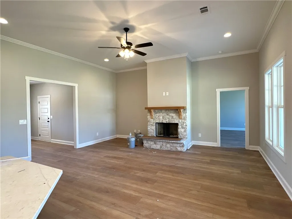 Rich wood flooring runs throughout this spacious living area highlighted by a stone fireplace.