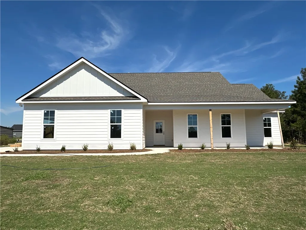 Crisp siding and a welcoming porch define this modern single-story home set against clear skies.