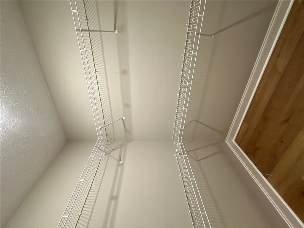 Ample wire shelving lines both sides of this functional walk-in closet space.