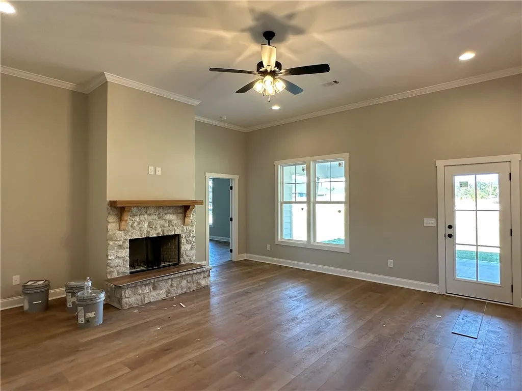 A stone fireplace anchors this living space accented by wood flooring and crown molding.