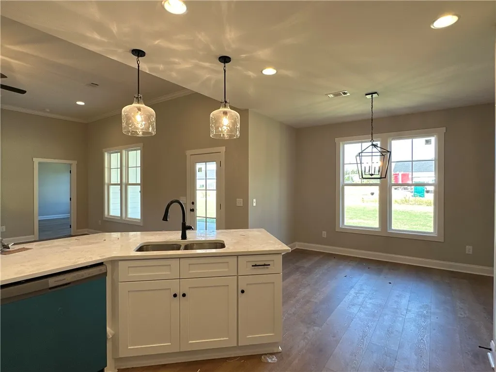 Rich wood floors anchor this open space seamlessly connecting the kitchen to the dining area.