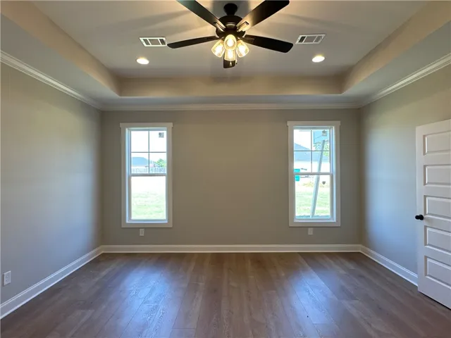 Elegant wood-look flooring and a recessed tray ceiling define this versatile space.
