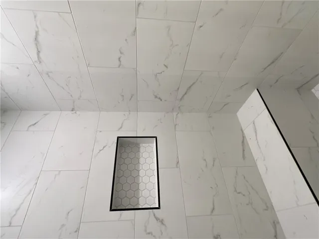 Elegantly veined wall tile surrounds a built-in niche with hexagonal accent detailing.