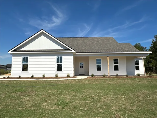 Crisp siding and a welcoming porch define this modern single-story home set against clear skies.