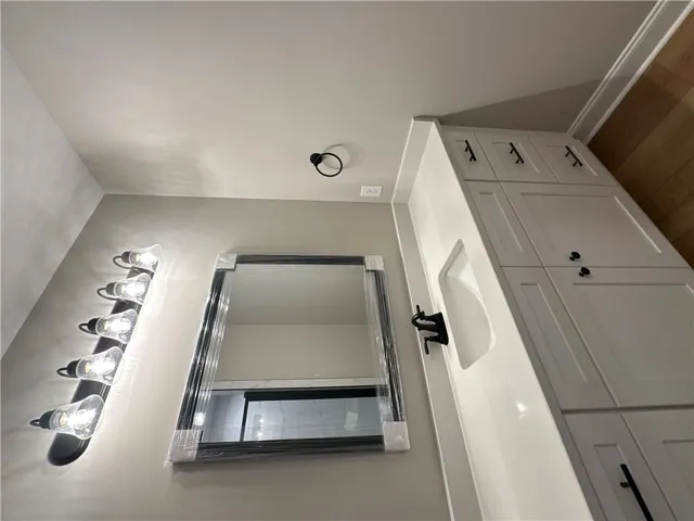 Gleaming hardwood floors and a modern vanity highlight this beautifully updated powder room.
