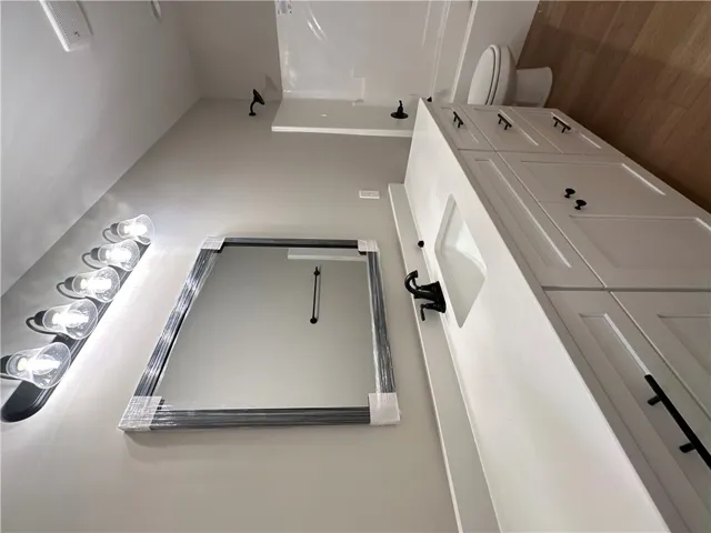 A spacious vanity with solid surface countertops highlights this sleek, modern bathroom space.