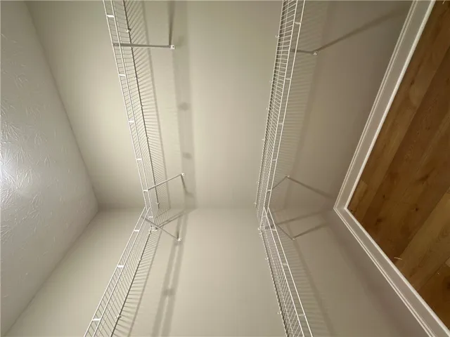 Ample wire shelving lines both sides of this functional walk-in closet space.