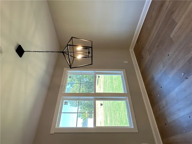 Large multi-pane windows fill the space with natural light highlighting the rich wood-style flooring.