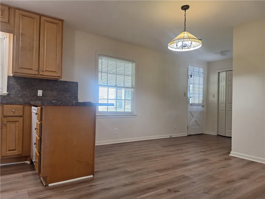 Natural light fills this functional dining area featuring wood-plank flooring and clean lines.