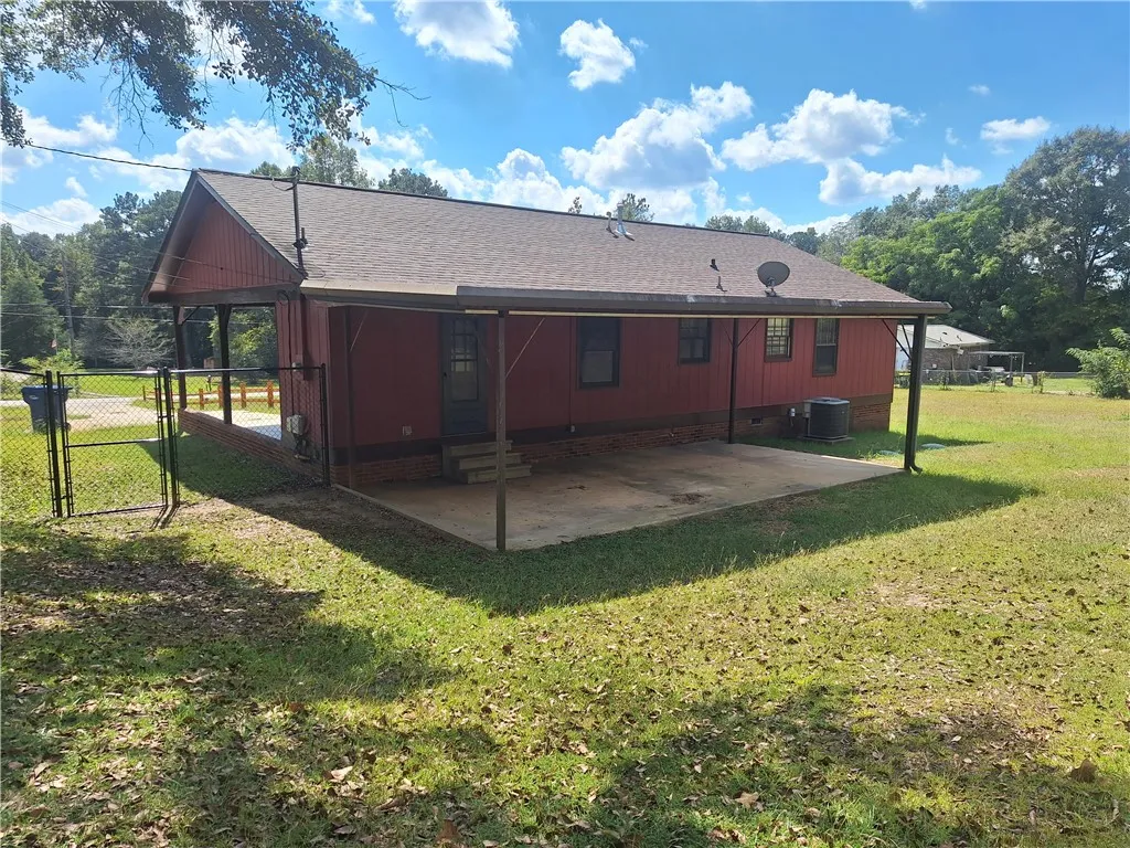 A spacious covered back patio looks out over the grassy yard.