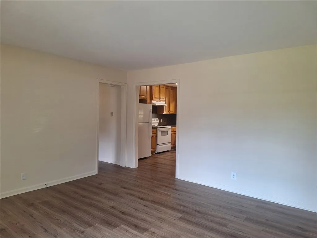 Gleaming wood-look floors anchor this versatile room offering a direct view into the kitchen.