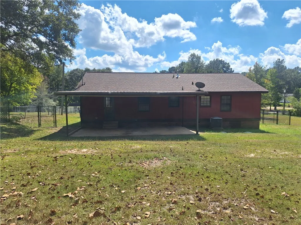 A spacious covered patio overlooks the grassy backyard of this charming home.
