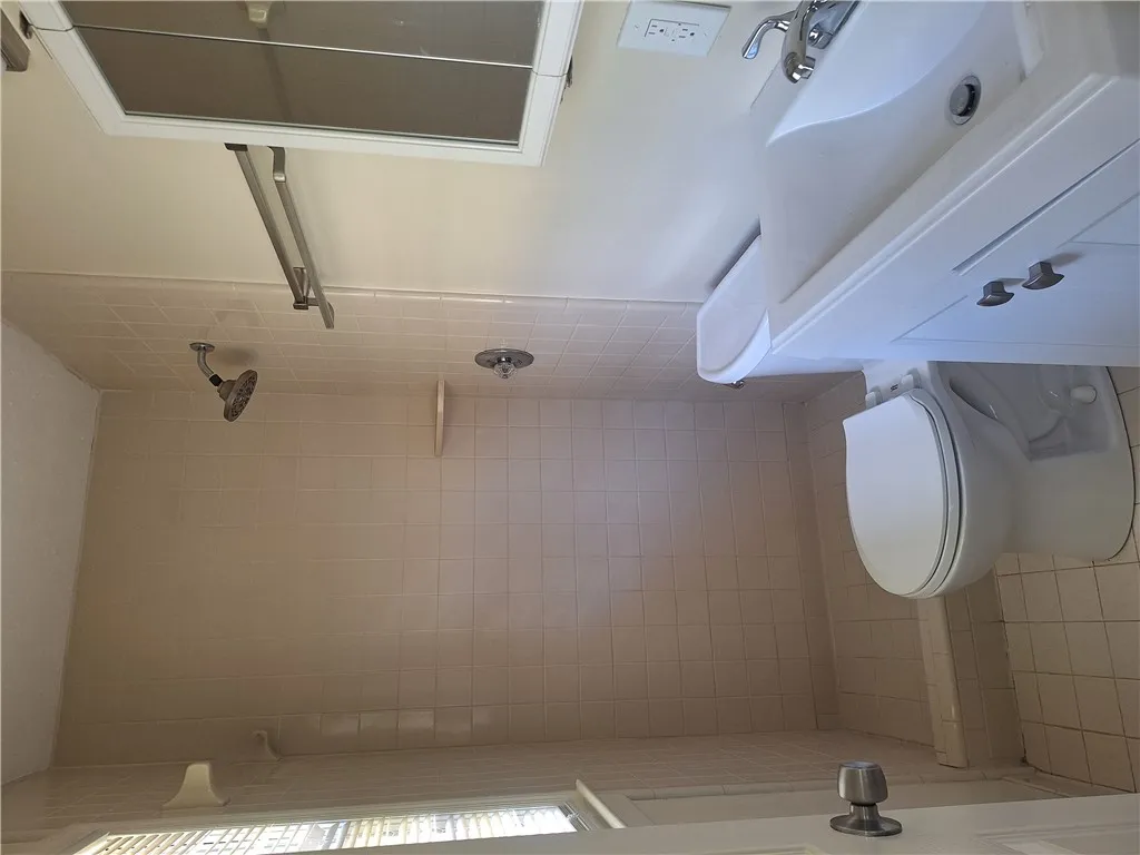 Tiled walls and a classic vanity define this functional bathroom space.