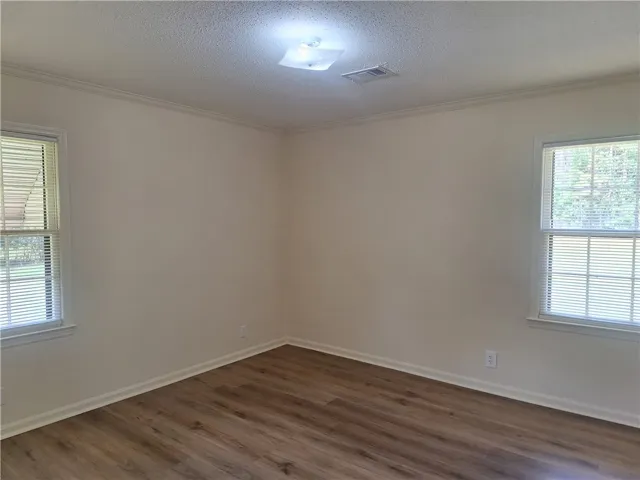 Gleaming wood floors pair with classic crown molding in this versatile room.