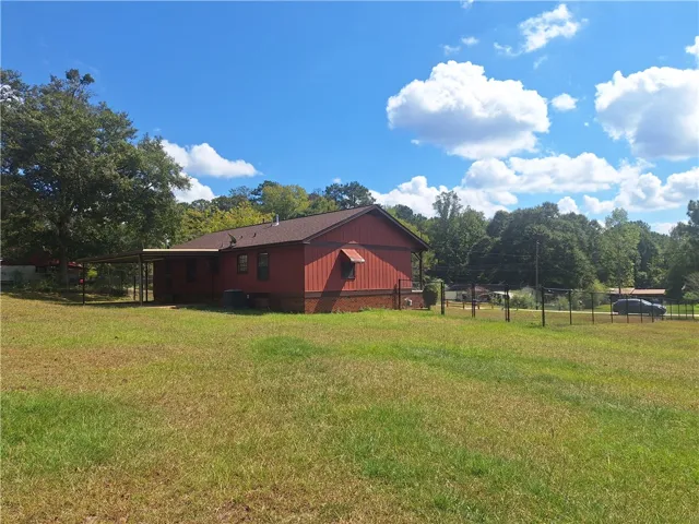 A spacious grassy lawn surrounds this classic single-story home with board and batten siding.
