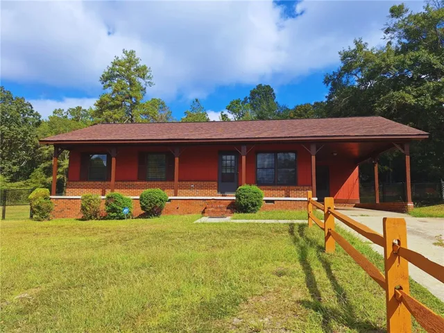 Classic brick and wood siding exterior featuring a deep covered porch and attached carport.