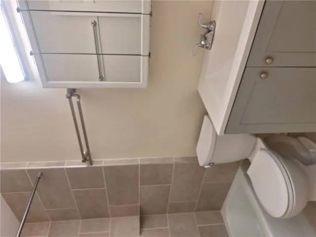 Tiled walls and classic fixtures define this compact bathroom layout.