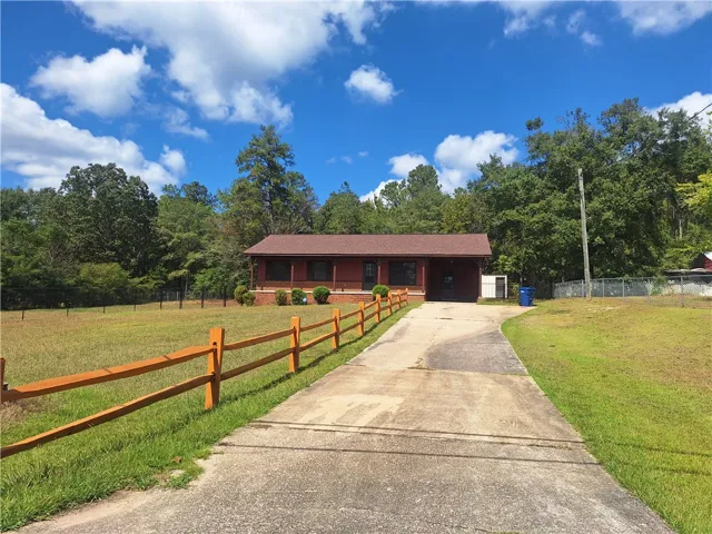 A long paved driveway leads up to this inviting country home nestled among mature trees.