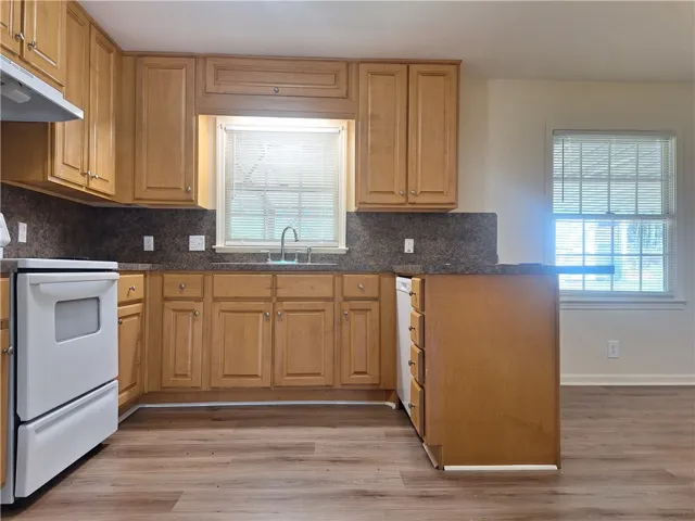 Ample wooden cabinetry and durable laminate flooring define this functional cooking space.