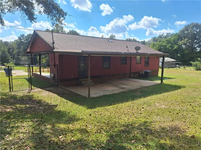 A spacious covered back patio looks out over the grassy yard.