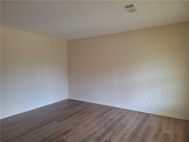Smooth plaster walls pair with clean baseboards and durable wood-look floors in this versatile interior space.