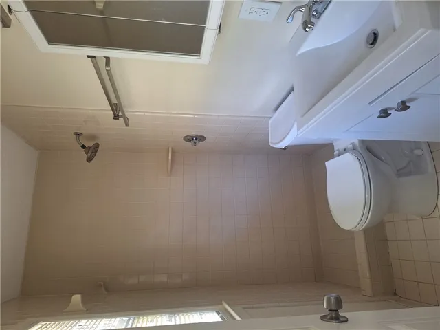 Tiled walls and a classic vanity define this functional bathroom space.